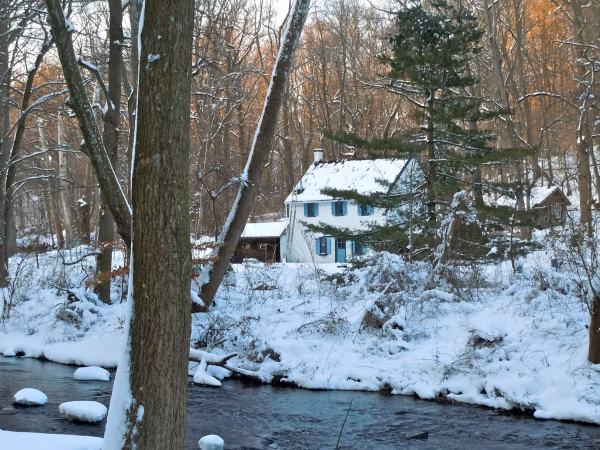 A white house beside Ridley Creek in snow near the old mill area of Ridley Creek State Park