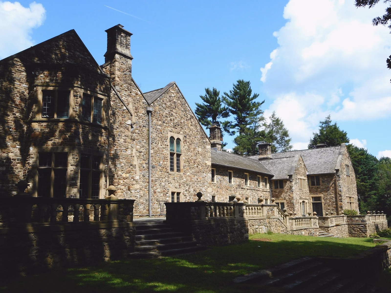 The stone rear facade and terrace of Hunting Hill Mansion, the wedding venue at Ridley Creek State Park