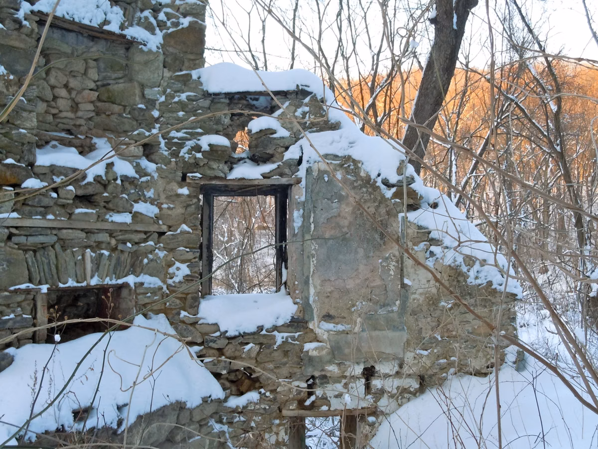 Snow-covered stone walls of a ruined worker's cottage in Ridley Creek State Park